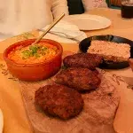 Albanisches Gericht mit Fërgesë und traditionellen Qofte, serviert in einem landestypischen Restaurant.