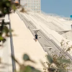 Ein Besucher steigt die markanten Stufen der Tirana-Pyramide hinunter – modernes Design trifft auf historische Bedeutung.