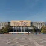 Nationalhistorisches Museum in Tirana mit ikonischem Mosaik und moderner Renovierung, im Hintergrund ein klarer blauer Himmel.