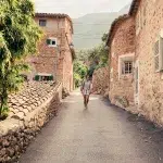 Frau spaziert in Gasse in Deia