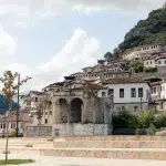 Historische Ruinen vor den typischen Häusern von Berat, Albanien, die sich an den Hang schmiegen.