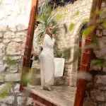 Reflexion einer Besucherin in einem rustikalen Holzrahmenspiegel, aufgenommen in einer charmanten Gasse von Berat, Albanien.