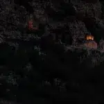 Alte Kapelle am Berghang, die im Dunkeln angeleuchtet wird.