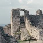 Ruinen der Burg von Berat, mit steinernen Mauern und Torbögen, die an die historische Bedeutung der Stadt erinnern.