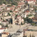 Blick auf den zentralen Platz und die orthodoxe Kathedrale von Berat, umgeben von traditionellen Häusern und moderner Architektur.