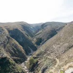 Weitläufige Berglandschaft mit Pfaden, die zur Ali-Pascha-Brücke führen – ein Paradies für Naturliebhaber und Wanderer.