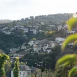 Blick auf die Altstadt von Gjirokastër bei Tageslicht – Die charakteristischen steinernen Häuser der Stadt verteilen sich malerisch auf den Berghängen.