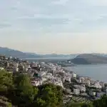 Panoramablick auf Ksamil und die umliegenden Hügel, mit dem strahlenden Blau des Ionischen Meeres im Hintergrund.