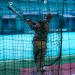 Mann im Batting Cage spielt Baseball