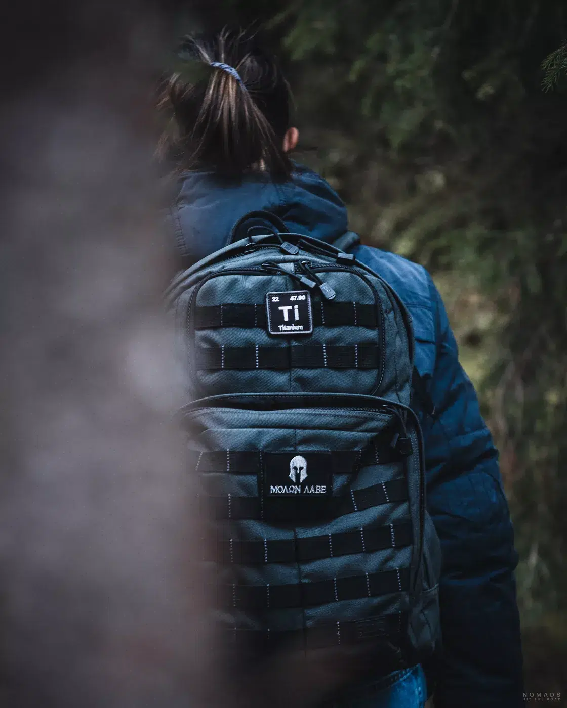 Wandererin mit Rucksack im Murnauer Moos – Nahaufnahme einer Frau von hinten, die mit einem robusten Rucksack durch die stille und grüne Natur des Mooses wandert.