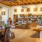 Verkaufsbereich im Murnauer Kaffeehaus mit Regalen voller Kaffeepackungen, Accessoires und einer gemütlichen Sitzgelegenheit im Vordergrund.