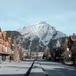 Kulisse auf einen Berg von der Hauptstraße in Banff, die gesäumt ist mit Häusern und Geschäften