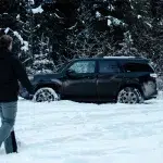 Mann läuft durch tiefen Schnee zum Auto am Shaden Viewpoint