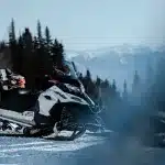 Nahaufnahme eines Ski-Doo Schneemobils mit Helm. Die leistungsstarken Maschinen ermöglichen ein einzigartiges Fahrerlebnis in der kanadischen Winterlandschaft.