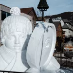 Eisskulptur eines Menschen, der durch eine große Lupe schaut in der Innenstadt von Banff zum SnowDays Festival