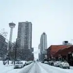 Blick auf Hochhäuser, den Calgary Tower und eine verschneite Straße