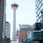 Blick auf den Calgary Tower von einer befahrenen Straße in Downtown