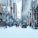 Verschneite Einkaufsstraße Stephen Avenue gesäumt von Geschäften