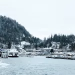 Winterliche Hafenlandschaft mit verschneiten Bergen und einer anlegenden Fähre auf Vancouver Island.