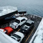 Fahrzeuge auf einer schneebedeckten Autofähre mit Blick auf das offene Wasser.