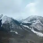 Verschneite Bergkulisse mit Bäumen entlang des Abhänge und im Tal