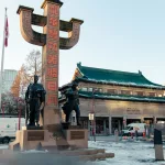 Statue mit chinesischer Inschrift vor einem Gebäude in Chinatown Vancouver