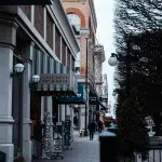 Belebte Straße in Victoria, BC, mit historischen Gebäuden, kleinen Geschäften und Fußgängern.