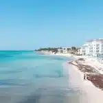 Blick auf ein Hotel am Strand von Playa del Carmen mit Sargassum am Strand