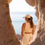 Frau blickt durch eine natürliche Felsöffnung aufs Meer – ruhiger Moment mit perfektem Ausblick über die Küste von La Paz.