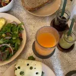 Frühstückstisch mit Brot, Salat, Aufschnitt und Saft