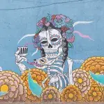 Street Art auf einer Häuserwand mit einem typisch mexikanischen Skelett und Blumen