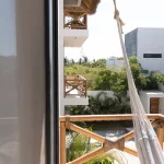 Blick von Hängematte auf Gebäude und Bäume