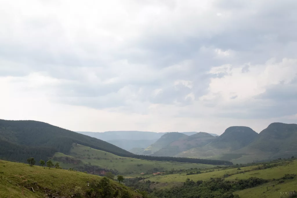 Blick über eine grüne Landschaft und Gebirge auf der Panorama Route in Südafrika