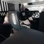 Blick auf den Sitzbereich mit Monitoren und persönlichen Bildschirmen in der Business Class bei Condor.