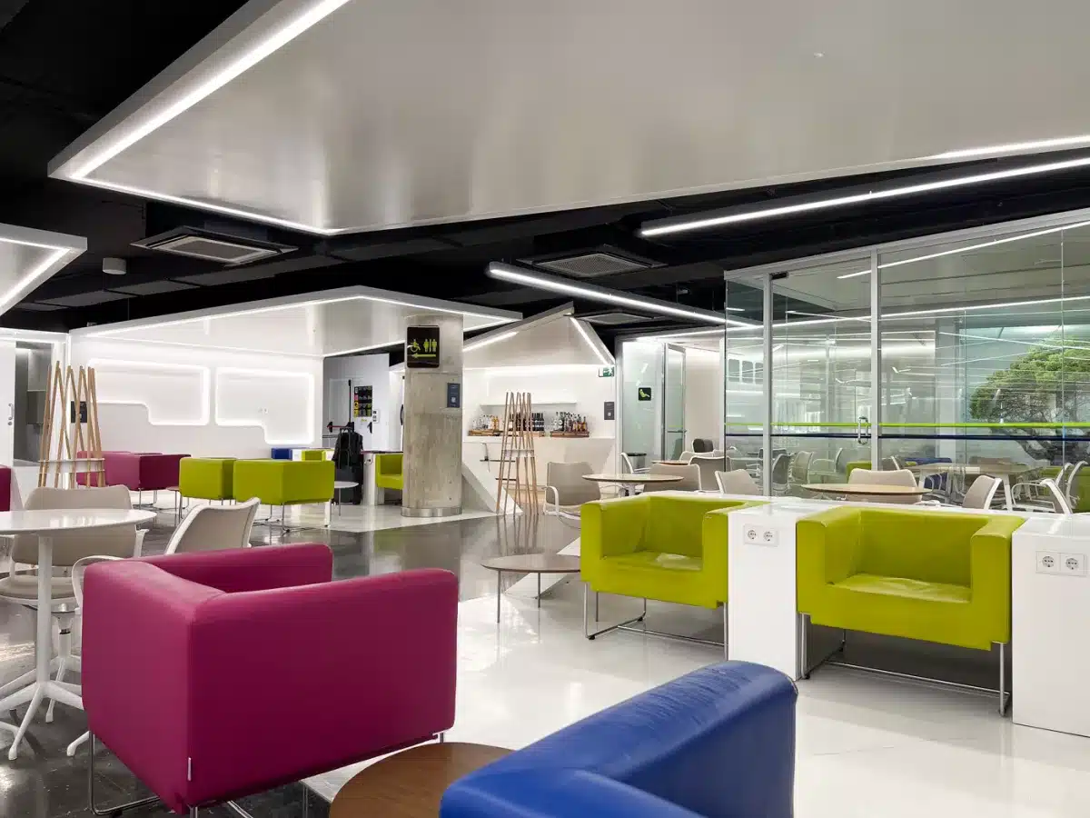 Ruhige Lounge mit modernen Sesseln und gedämpftem Licht, Menschen sitzen entspannt.