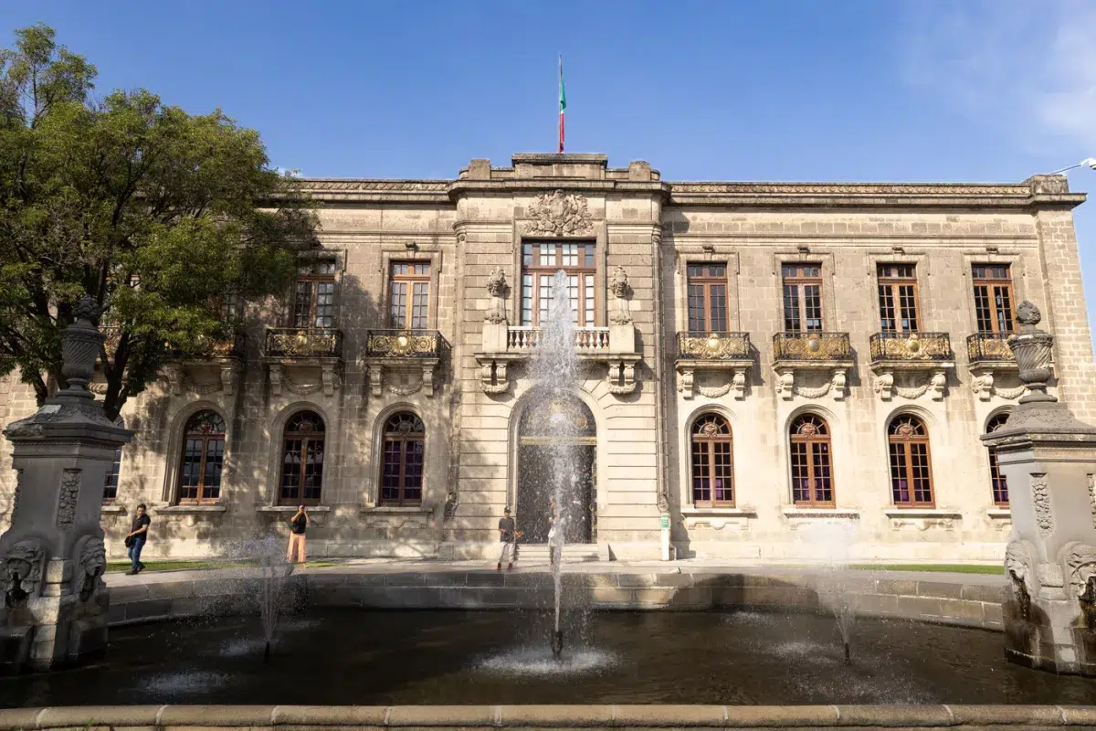 Außenansicht des Castillo de Chapultepec mit Brunnen und Flagge bei Tageslicht, ein Symbol kolonialer Pracht.