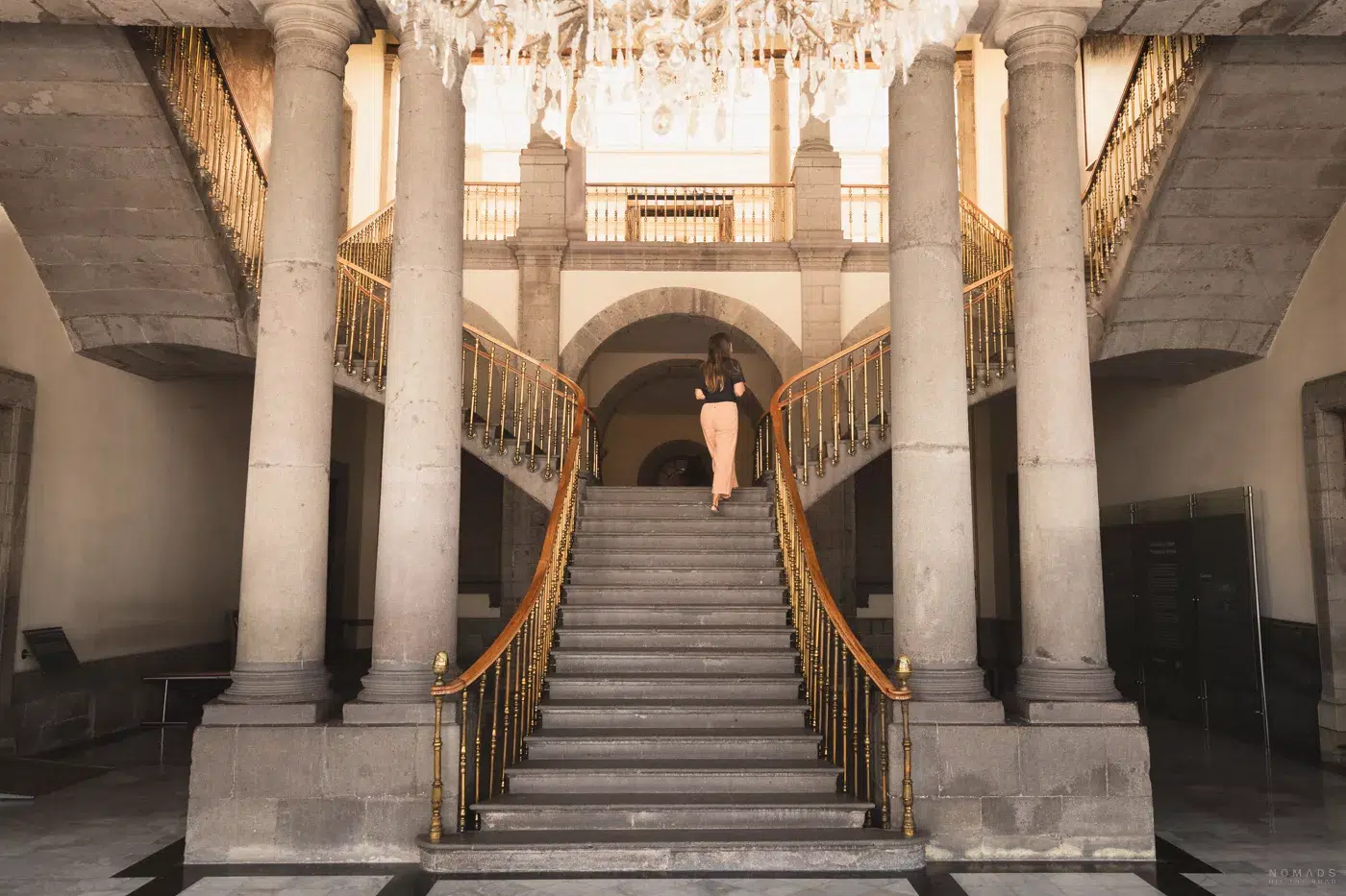 Eingangshalle im Castillo de Chapultepec mit prunkvoller Doppeltreppe und klassischer Säulenarchitektur.