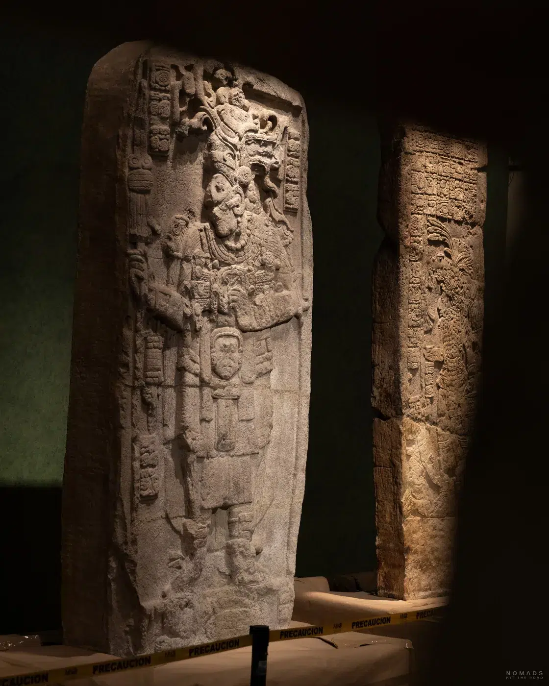Relief-Stele mit feinen Schnitzereien im Halbdunkel des Museums.