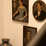 Ein Blick in einen Raum der Casa Azul, dem ehemaligen Wohnhaus von Frida Kahlo, der eine Sammlung von traditionellen mexikanischen Kunsthandwerken und Objekten zeigt. Die Wände sind in einem kräftigen Blau gestrichen, und die Gegenstände sind auf Regalen und in Vitrinen arrangiert.