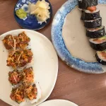 Verschiedene Sushi-Rollen auf Keramiktellern mit eingelegtem Ingwer und Wasabi in einem japanischen Restaurant in Mexiko City