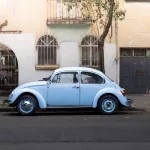 Hellblauer VW Käfer parkt vor einer alten Hausfassade im Viertel Condesa, Mexiko-Stadt