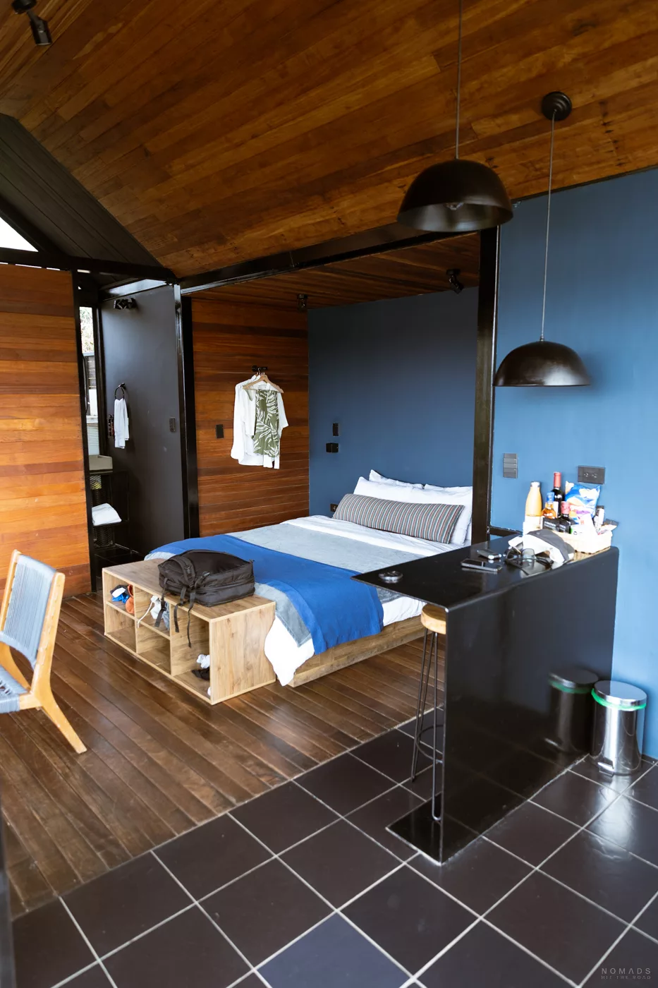 Modernes Hotelzimmer im Boato Hotel in Guatapé, Kolumbien, mit gemütlichem Bett, Holzinterieur und offenem Badezimmerbereich.