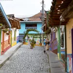 Pittoreske Kopfsteinpflastergasse in Guatapé, Kolumbien, mit bunten Fassaden und Straßenkunst