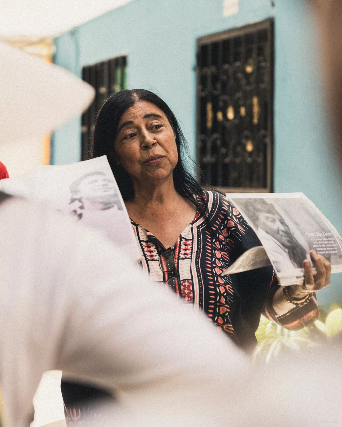 Frau in Medellín erzählt während einer Stadtführung von der Geschichte Kolumbiens und zeigt Fotos aus der Vergangenheit.