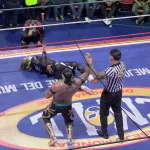 Gewinner beim Lucha Libre wird vom Schiedsrichter angezeigt während der Gegner am Boden liegt