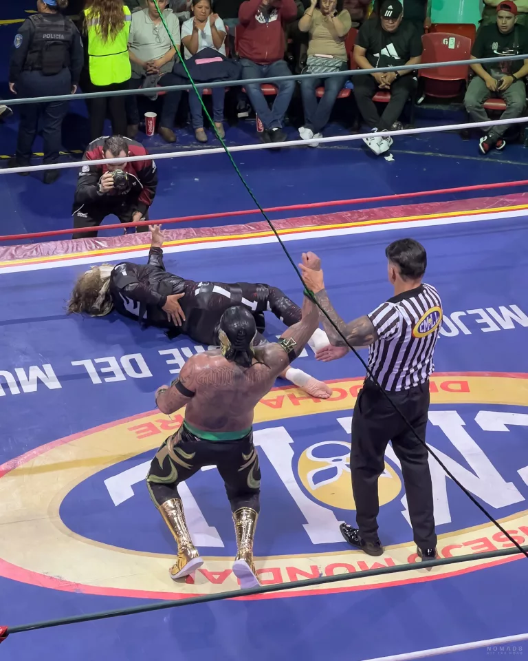 Gewinner beim Lucha Libre wird vom Schiedsrichter angezeigt während der Gegner am Boden liegt