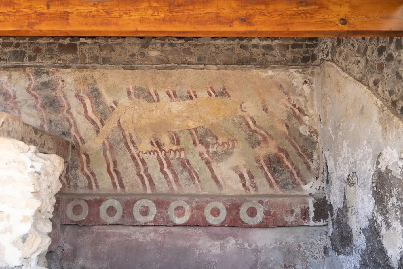 Gut erhaltene prähispanische Wandmalerei (Mural del Puma) eines gelblichen Pumas mit roten Krallen auf einem Hintergrund aus wellenförmigen Linien in Rot und Grün, entdeckt in einer Residenz in Teotihuacán.
