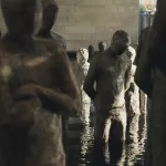 Steinfiguren im Wasser in der Handelskammer von Medellín – Kunstinstallation, die den Entwicklungsweg von Unternehmern symbolisiert.