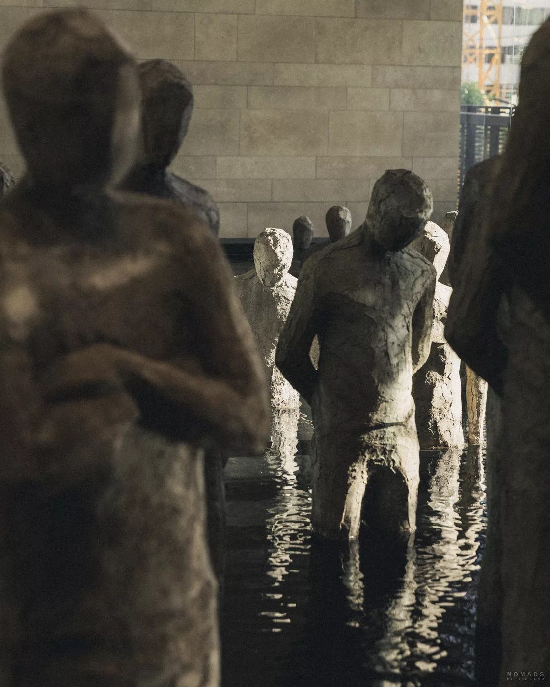 Steinfiguren im Wasser in der Handelskammer von Medellín – Kunstinstallation, die den Entwicklungsweg von Unternehmern symbolisiert.
