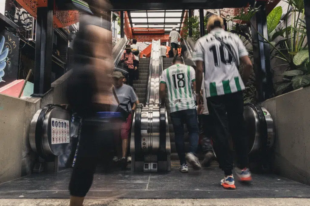 Menschen nutzen die überdachten Rolltreppen in der Comuna 13 in Medellín, ein Symbol für den Wandel und die bessere Anbindung des Viertels.